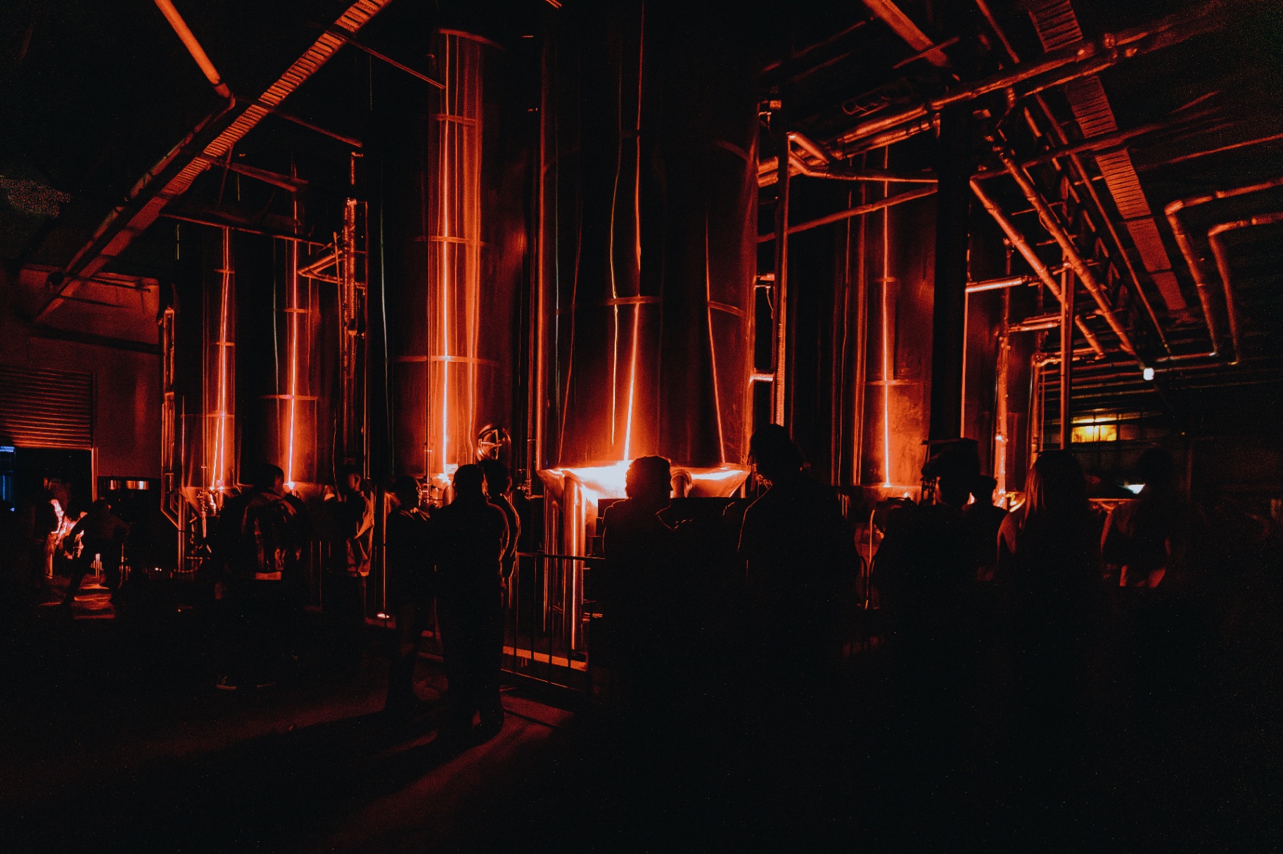 M87 distillery party with copper stills under red light